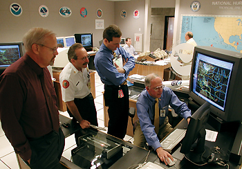 Photo showing National Hurricane Center Director Max Mayfield previewing Hurricane Michelles track for (from left) Jim Lushine, Warning Coordination Meteorologist, WFO, Miami; Chuck Lanza, Director, Emergency Management, Miami-Dade County; and an unidentified aide.