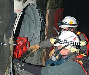 Photo showing NIST electrical engineers Chris Holloway and Galen Koepke placing transmitters in a protected air vent at the old Washington Convention Center prior to the implosion of the building.