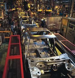 Photo showing an assembly line in a car manufacturing plant.