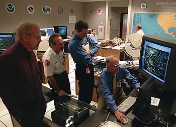 Photo showing National Hurricane Center Director Max Mayfield previewing Hurricane Michelle's track for (from left) Jim Lushine, Warning Coordination Meteorologist, WFO, Miami; Chuck Lanza, Director, Emergency Management, Miami-Dade County; and an unidentified aide.