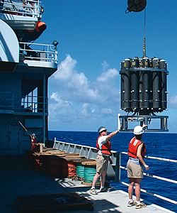 Photo showing NOAA's Ocean Exploration scientists launching the CTD (conductivity, temperature, depth) over the side of the research vessel Thompson to take ocean measurements.